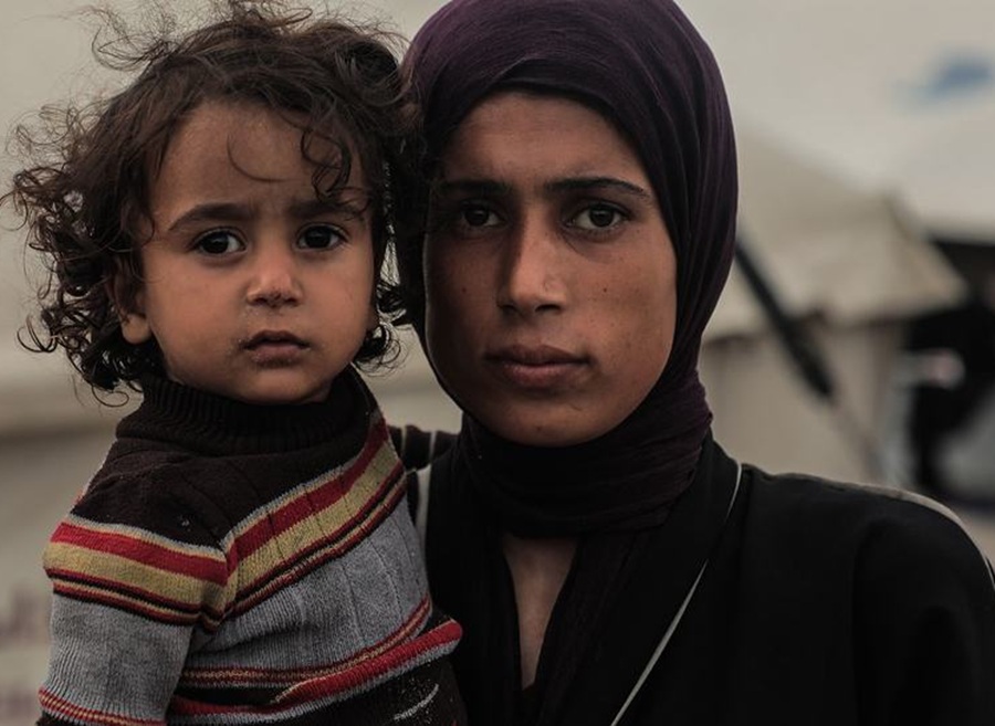 mujer palestina y su hijo frente a tienda en la que viven en gaza